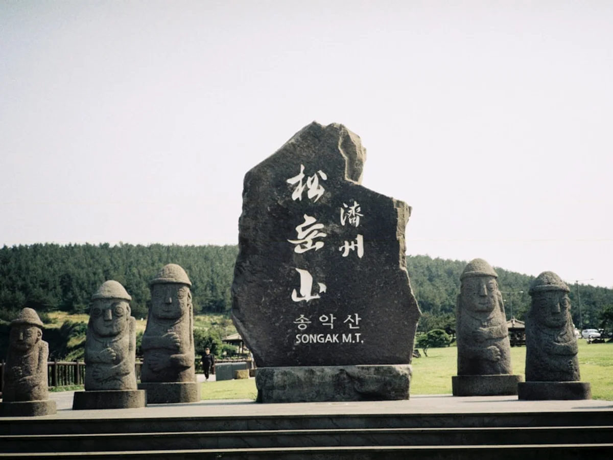 Stone statues and monument on grassy hill. related to Discover the history of in Korea